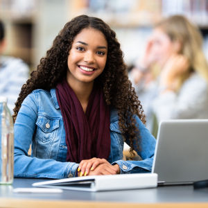 teen girl seated in front of laptop